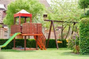 a playground with a slide in a yard at Family Hotel Vega in Saints Constantine and Helena