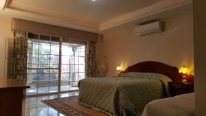 珀斯Vimal's Homestay的一间卧室，里面有一张床和一扇大窗户。