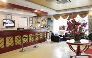 una sala d'attesa con bancone e tavolo con fiori di GreenTree Inn Weihai Qingdao North Road Branch a Weihai