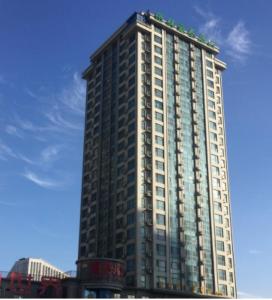 Un edificio alto con muchas ventanas. en GreenTree Inn Weihai Qingdao North Road Branch, en Weihai