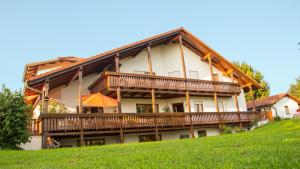 Casa grande con balcones de madera en una colina en Auszeit-Wohnungen, en Aidenbach