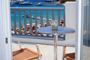a table on a balcony with a view of the beach at Hotel Anna in Platis Gialos