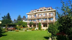 a large building with a lawn in front of it at Family Hotel Vega in Saints Constantine and Helena