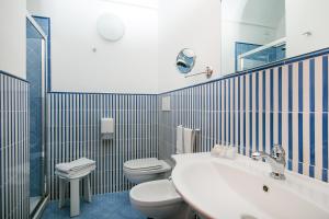 a bathroom with a sink and a toilet and a mirror at Hotel Pupetto in Positano