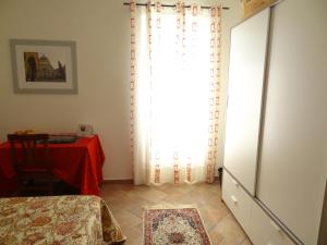 een kamer met een tafel en een raam met een rood gordijn bij B&B Bergamo e Brescia in Rodengo Saiano