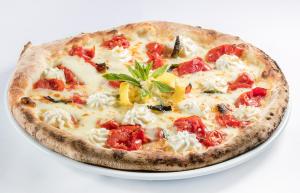 a pizza sitting on a plate on a table at Hotel Pupetto in Positano