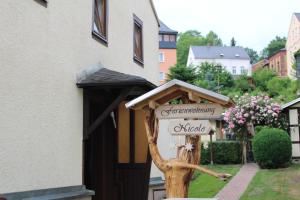 a sign on a tree in front of a house at Ferienwohnung Nicole in Schneeberg