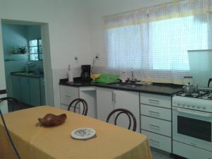 a kitchen with a table and a sink and a stove at Casa Suiza in Luis Guillón