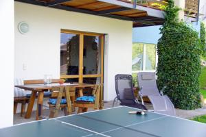 eine Terrasse mit einem Tisch und Stühlen vor einem Haus in der Unterkunft Appart Manuela in Arzl im Pitztal