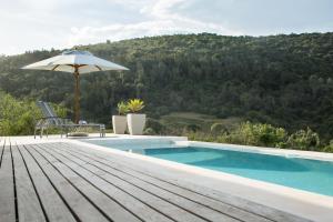 a swimming pool with an umbrella and a table at Hopewell Private Game Reserve in Buyskloof