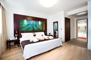 um quarto com uma cama grande e uma pintura grande na parede em Mercure Olbia em Olbia