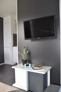 una mesa blanca con TV en la pared en Stadscamping Zeeland, en Middelburg