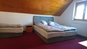 a room with two beds and a chair in it at Flamingó Panzió in Székesfehérvár