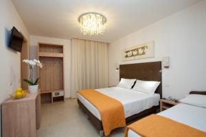 a hotel room with two beds and a chandelier at Hotel Ristorante Cesare in Savignano sul Rubicone