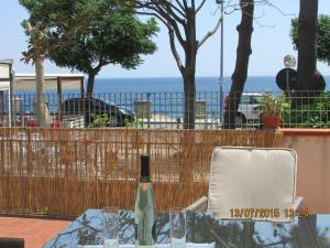 una botella de vino sentada en una mesa con una valla en Villetta singola "Lilla", en Ali Terme