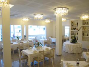 a dining room with white tables and chandeliers at Hotel Ristorante Cesare in Savignano sul Rubicone
