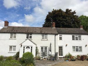 une maison blanche avec un arbre en arrière-plan dans l'établissement Fern Cottage, à Dorchester