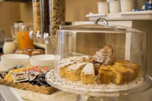 a glass dish filled with bread and pastries on a counter at Casa Elide in Catania
