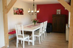 a dining room with a white table and chairs at Ferienhaus Sonneneck in Sebnitz