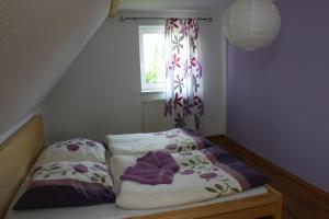 a small bed with two pillows and a window at Ferienhaus Sonneneck in Sebnitz
