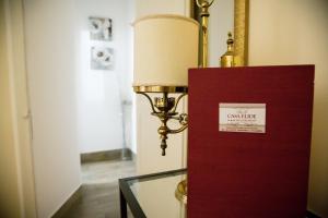a lamp next to a glass table with a sign on it at Casa Elide in Catania