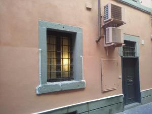 ローマにあるAppartamento della Chiesa Nuovaのピンクの建物の窓(ドア、エアコン付)