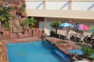 - une piscine avec parasols en face de l'hôtel dans l'établissement Hotel San Rafael, à Poza Rica de Hidalgo