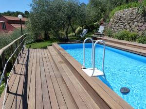 una terraza de madera junto a una piscina en Belvedere Lodge en Chiavari