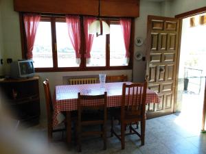 a dining room with a table and chairs and a television at Casa Tirador in San Martin del Mar