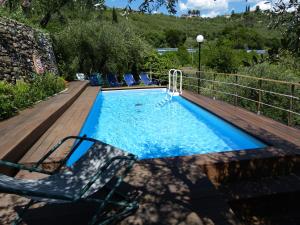 a swimming pool with a deck and a chair next to it at Belvedere Lodge in Chiavari