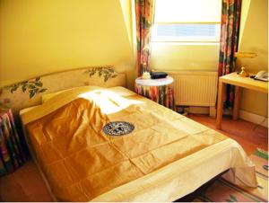 Bett in einem Zimmer mit Fenster in der Unterkunft Hotel Gasthaus Krone in Köln