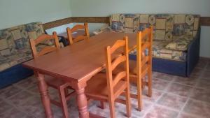 a wooden table with four chairs and a couch at Appartement A Mas Oliva in Roses