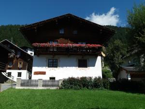 Casa blanca con balcón con flores. en Haus Antonius, en Sankt Lorenzen im Lesachtal
