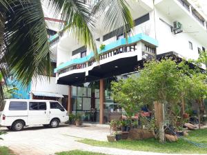 un furgone bianco parcheggiato di fronte a un edificio di Relax Inn Hikkaduwa a Hikkaduwa
