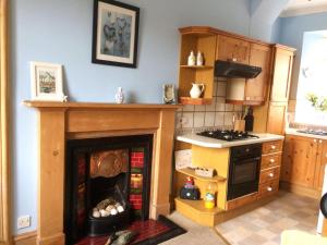 a kitchen with a toy stove and a fireplace at The Gables in Crail