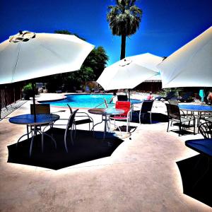 een groep tafels en parasols naast een zwembad bij Sterling Gardens in Las Vegas