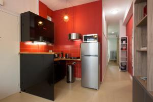 een keuken met rode muren en een koelkast bij Under the shade of Acropolis in Athene