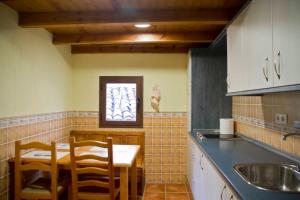 a kitchen with a table and chairs and a sink at Ático en la Plaza Mayor in Cuenca
