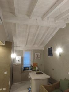 アラッシオにあるAppartamento centro Alassioの白い格子天井のキッチン(シンク付)