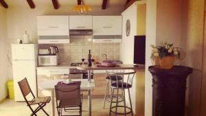 a kitchen with a table and chairs and a kitchen with white cabinets at Apartmani Mersol Nin in Nin