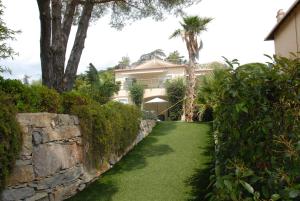 聖馬克西姆的住宿－Sainte Maxime 3 pièces，一座带石墙和绿色草坪的房屋