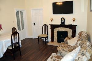 Ash Tree Cottage في Bangor: غرفة معيشة مع أريكة ومدفأة
