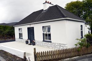 um chalé branco com um telhado preto em Ash Tree Cottage em Bangor