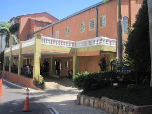 a large brick building with a balcony on a street at Apartamento Giardino Rio Quente in Rio Quente