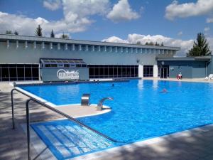 a large swimming pool in front of a building at Chata nad kúpaliskom in Kováčová