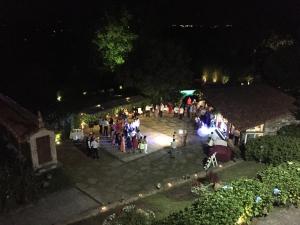 Un gruppo di persone in piedi in un cortile di notte di Casa Grande de Fuentemayor a Silleda Altre 53 foto
