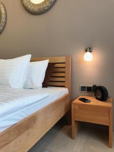 プラハにあるArt Suites Spalenaのベッドルーム1室(ベッド1台、時計付きテーブル付)