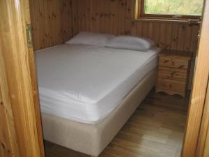 a bed in a room with a wooden floor at Vestri Pétursey in Vestri Pétursey