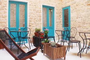 un patio con sillas, mesas y puertas azules en Duma Apartments Sibenik en Šibenik