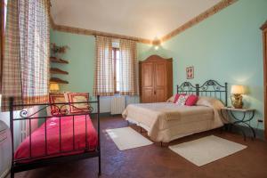 a bedroom with a bed and a red suitcase at Villa Angelica in Peccioli